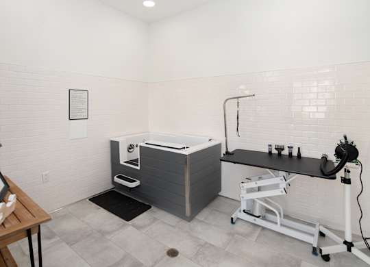A bathroom with a white tub and a black counter.