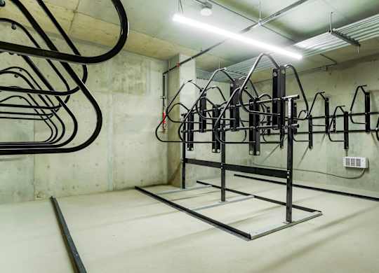 A gym with a white wall and a black cable machine.