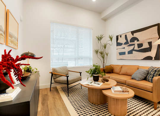 A living room with a couch, chair, and a table with a vase on it.