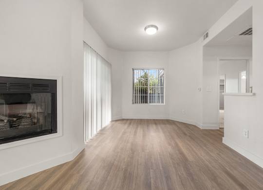 Modern apartment living room with a fireplace and natural lighting.