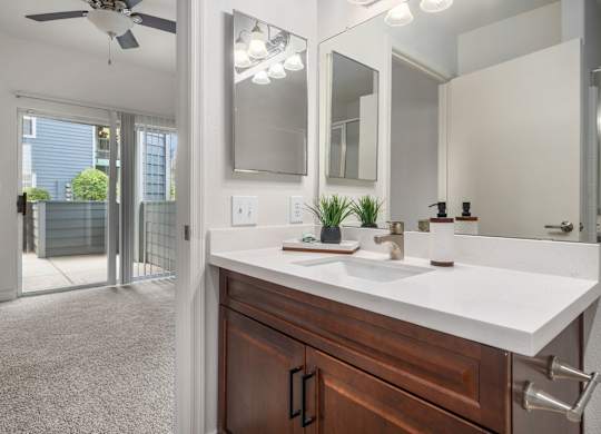 A spacious primary bathroom with white countertop.