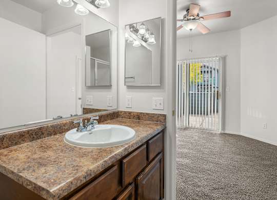A bathroom with a granite countertop and a white sink.