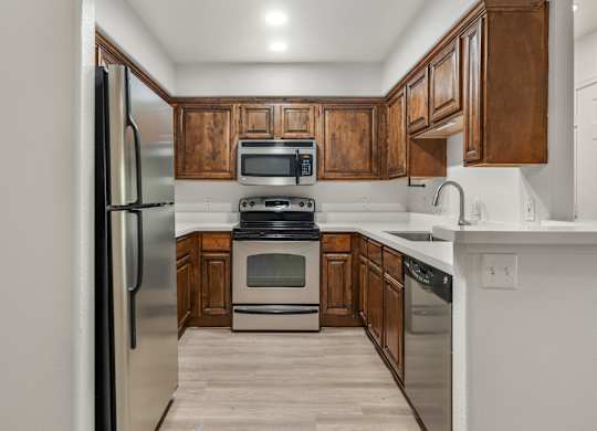 A kitchen with wooden cabinets and stainless steel appliances.