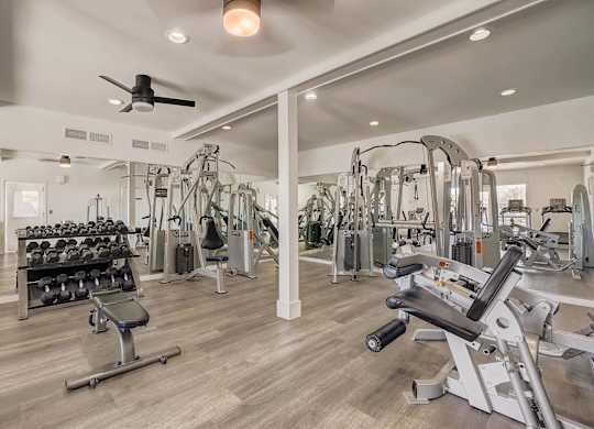 A spacious gym with a variety of equipment including treadmills, weights, and exercise machines.