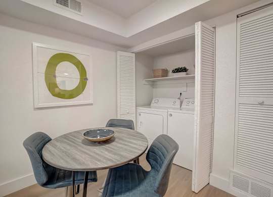 A dining room with a round table and chairs.
