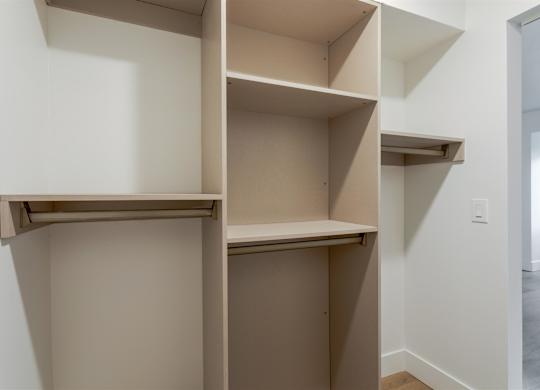 A white wall with a shelf and a doorway.