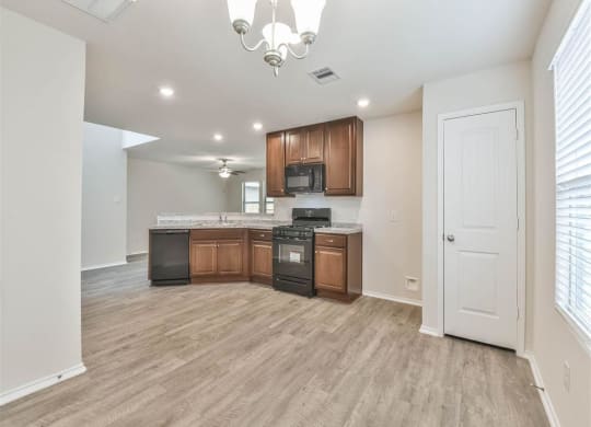 a living room with a staircase and a kitchen at The Village at Caney Mills, Texas, 77303