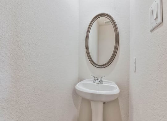 a bathroom with a sink and a mirror at The Village at Caney Mills, Conroe, TX