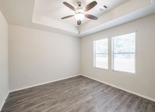an empty living room with a ceiling fan and a window at The Village at Caney Mills, Texas, 77303