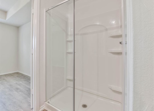 a white shower in a bathroom with a glass door at The Village at Caney Mills, Conroe, TX, 77303