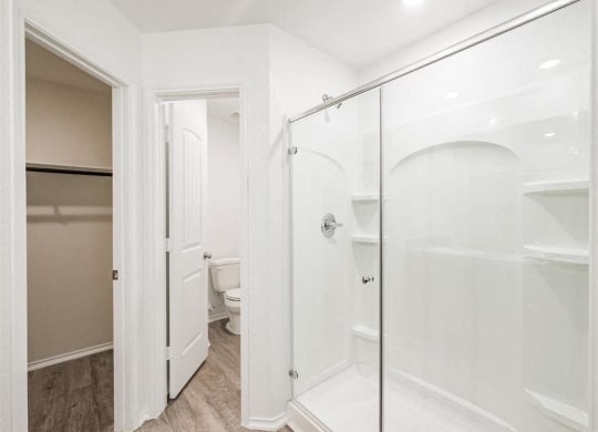 a bathroom with a shower and a toilet in it at The Village at Caney Mills, Conroe, TX, 77303