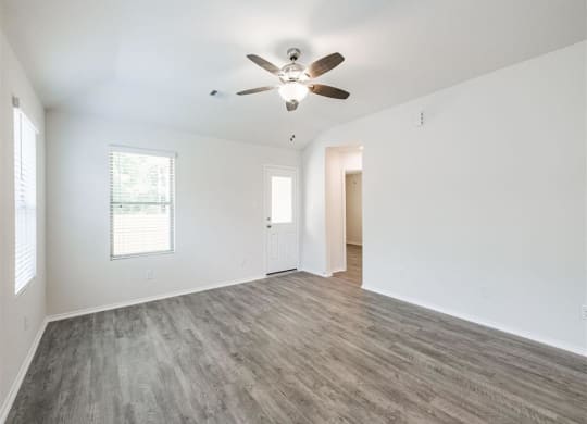 an empty living room with a ceiling fan at The Village at Caney Mills, Conroe, Texas