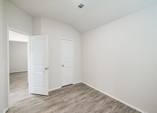 an empty bedroom with a door and a closet at The Village at Caney Mills, Conroe, TX, 77303