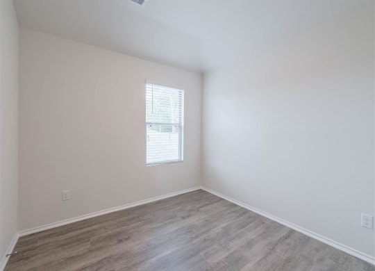 an empty room with white walls and a window at The Village at Caney Mills, Conroe, Texas