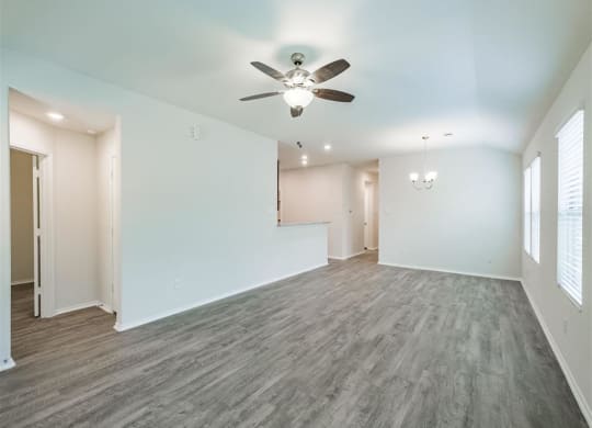 a living room with white walls and a ceiling fan at The Village at Caney Mills, Conroe, TX, 77303
