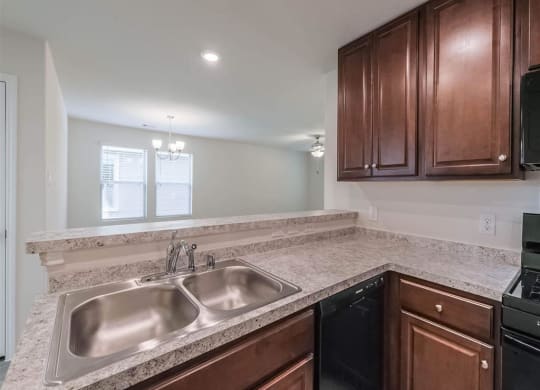 a kitchen with a sink and wooden cabinets at The Village at Caney Mills, Texas, 77303