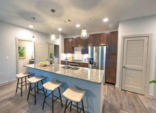 a kitchen with a large island with bar stools