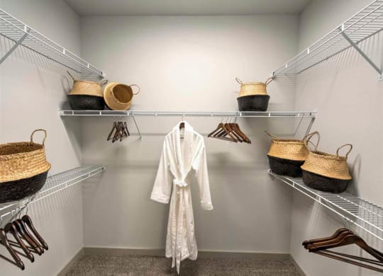 a white robe and baskets in a walk in closet