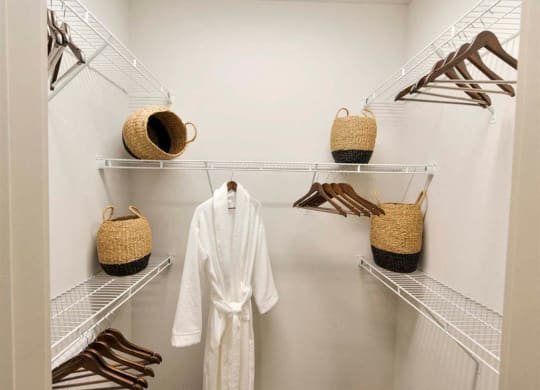a white robe and some baskets in a closet