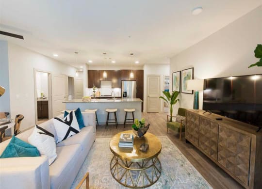 a living room and kitchen with a couch and a table