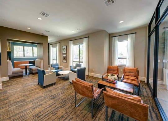 a lounge area with chairs and tables and windows