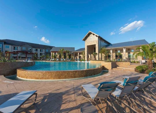 a swimming pool with chairs and a building in the background