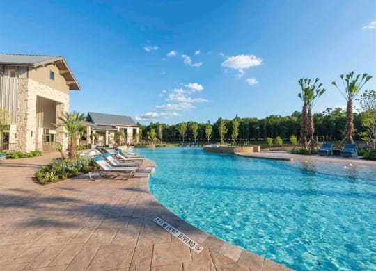 a swimming pool with lounge chairs next to a building