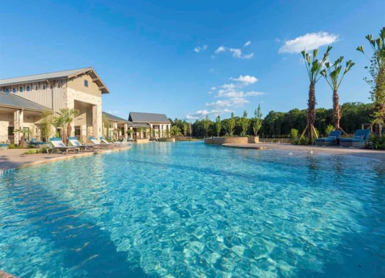 a large swimming pool in front of a resort with palm trees