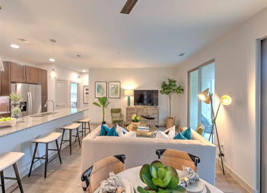a living room and a kitchen with a table and chairs