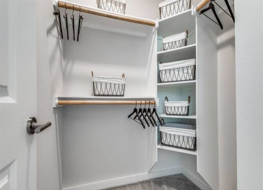 a walk in closet with shelves and baskets