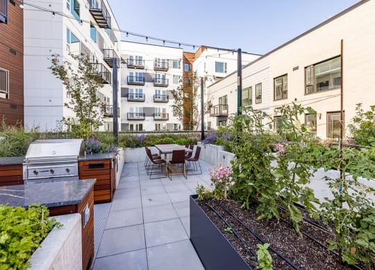 a patio with a grill and a table and chairs