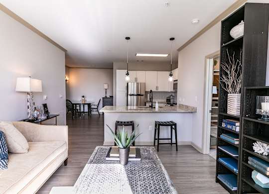 a living area with a couch a coffee table and a kitchen in the background at Westmount at Ashwood, Atlanta