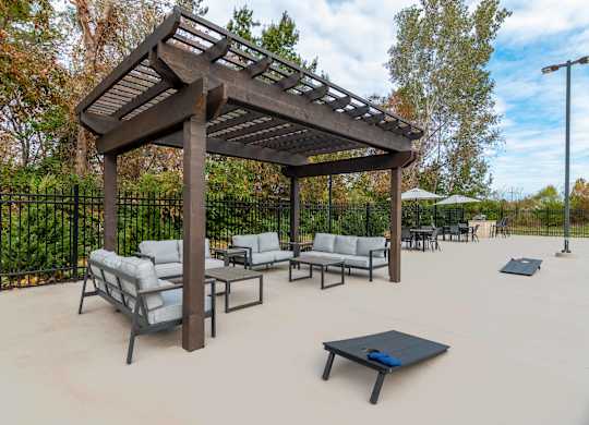 a patio with couches and tables and a wooden pavilion