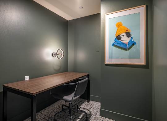 a study area with a desk and a painting on the wall