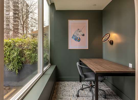 a room with a table and a window and a painting of a horse