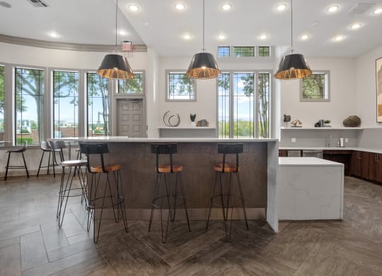 a kitchen with a marble counter top and bar stools at Mission Gate, Plano, Texas