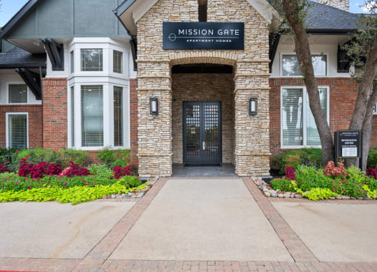 the entrance to mission gate residential building with a blue sign on top of the door at Mission Gate, Texas