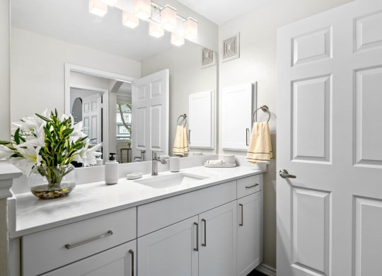 a white bathroom with two sinks and a mirror at Mission Gate, Plano