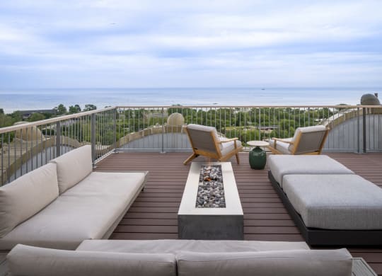 a terrace with couches and chairs overlooking the ocean at the Belden Stratford in Chicago, 60614