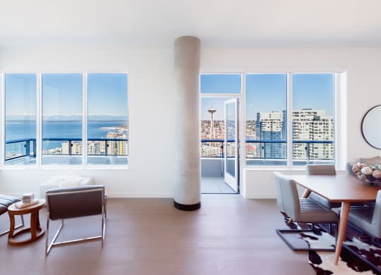 A living room with a view of the city and the sea.