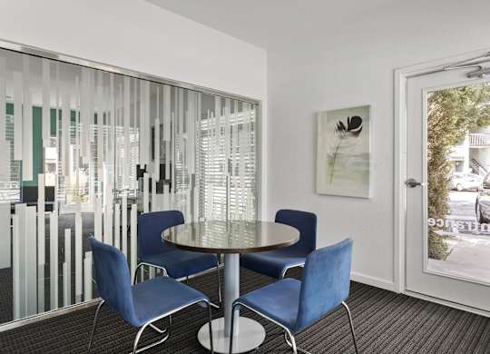 a dining area with blue chairs and a glass table  at Verona, Littleton, 80123