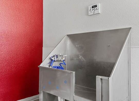 a stainless steel bathroom with a sink and a red wall  at Verona, Colorado, 80123