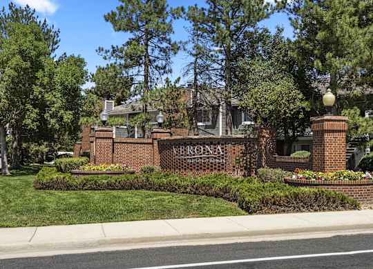 the front of a brick building with a sign that reads  at Verona, Littleton, CO, 80123