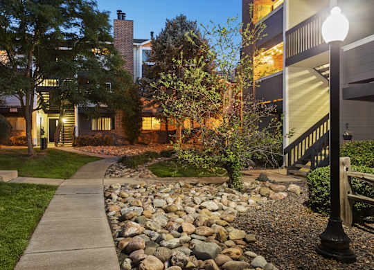 a walkway with a sidewalk and rocks in front of a house  at Verona, Littleton, CO