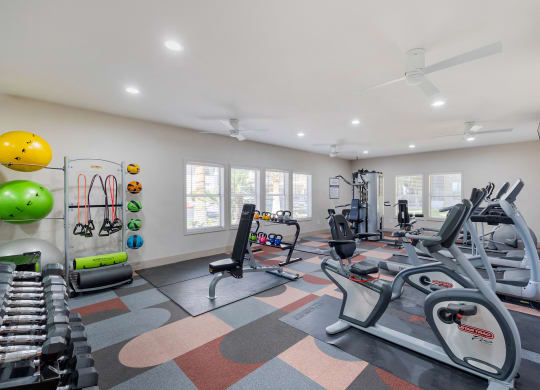 a gym with treadmills and other exercise equipment and windows at Paisley and Pointe Apartments, Las Vegas, 89130