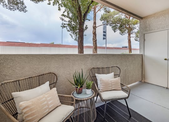 a balcony with two chairs and a table at Paisley and Pointe Apartments, Las Vegas, NV 89130