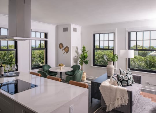 a kitchen with a white counter top and a living room  at The Belden Stratford, Chicago, Illinois