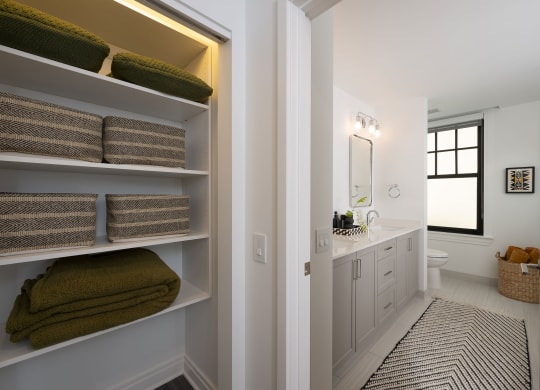 a bathroom with a sink and shelves with towels  at The Belden Stratford, Chicago, 60614