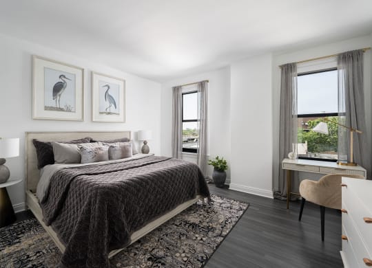 a bedroom with a bed and two windows  at The Belden Stratford, Chicago, IL