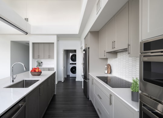 a large kitchen with white counter tops and black appliances  at The Belden Stratford, Chicago, 60614